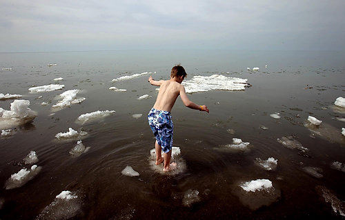 First Place, Photographer of the Year/Large Market - Lisa DeJong / The Plain DealerA shirtless Shawn Hurr, 11,  of Cuyahoga Falls, tries to balance on a floating ice chunk at Headlands Beach State Park in Mentor on Friday, April 2, 2010.  Floating ice chunks and huge white icebergs made beach goers do a double take as temperatures rose to a record high of 83 degrees. "I didn't know if it was foam first or what," says Shawn Hurr, Shawn Hurr's father ( both have same name.) " I figured the water would be cold, but not with icebergs."  The Hurrs made the trip up on the last day of Shawn's springbreak. 