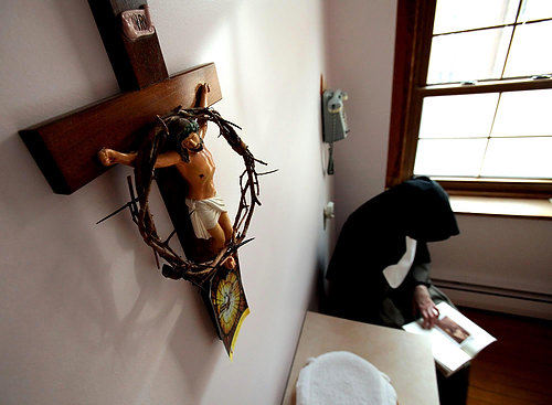 First Place, Photographer of the Year/Large Market - Lisa DeJong / The Plain DealerThe Crown of Thorns, which is presented to a Sister when she takes her solemn vows, looks over Mother Dolores as she reads the poetry of her favorite poet, Robert Frost, inside her frugal "cell", her bedroom, inside her cloistered living quarters.