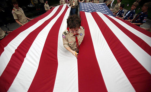 Second Place, Photographer of the Year/Large Market - Gus Chan / The Plain DealerMichael Huber, a boy scout with Troop 367, cuts a large flag in half as part of the flag retirement ceremony at Lake View Cemetery.