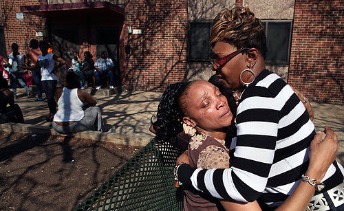 Second Place, Photographer of the Year/Large Market - Gus Chan / The Plain DealerPatricia Bradley is offered condolences as she sits outside her W. 25 St. apartment.  Bradley is the mother of Angel Crockett, who was found on the side of the road near I-90 and W. 41 St. Monday morning.  Crockett had been strangled and hit with a blunt instrument and her body dumped on the side of the road. 