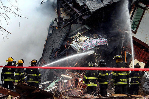 First Place, Photographer of the Year/Large Market - Lisa DeJong / The Plain DealerA bed hangs out of an upstairs bedroom as Cleveland firefighters battle a blaze last Jan. 25 caused by an explosion in a vacant house next to this home on West 83rd Street. Fifteen families were left homeless by the fire. A neighbor was subsequently arrested for arson but found not guilty. 