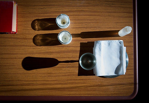 First Place, Student Photographer of the Year - Joel Hawksley / Ohio UniversityThe Word of the Lord, candles, and fixings for communion sit on a table in the cafeteria at Hocking Creek Nursing Home. Father Holler brings his "church in a box" with him to the home once a month. 