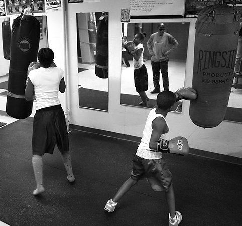 Second Place, Sports Picture Story - Carrie Cochran / Cincinnati EnquirerRay watches as both of his children, Raynesha, 13, left, and Ray Ray, 10, work on the punching bags. Ray Ray has won national championships, and his father believes he has a chance to make it to the Olympics. But right now he's more concerned with Raynesha. "She just went off track," he said.