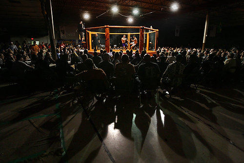 First Place, Sports Picture Story - Ed  Suba Jr / Akron Beacon JournalA large crowd of enthusiastic fans watch a full card of bouts in a restaurant banquet area during Caged Madness, an amateur mixed martial arts event.