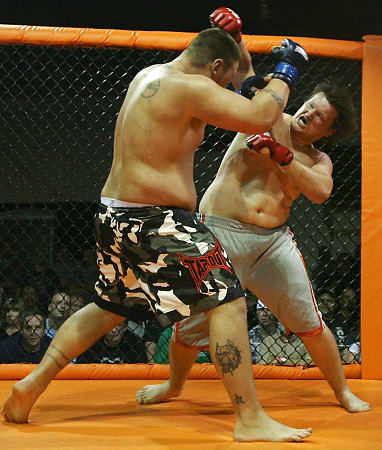 First Place, Sports Picture Story - Ed  Suba Jr / Akron Beacon JournalCurt Lemmon exchanges punches with his opponent, Clay Wetzel, in their bout at Caged Madness, an amateur mixed martial arts event.