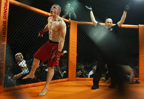 First Place, Sports Picture Story - Ed  Suba Jr / Akron Beacon JournalA fighter celebrates after knocking out his opponent during during his match at Caged Madness, an amateur mixed martial arts event.