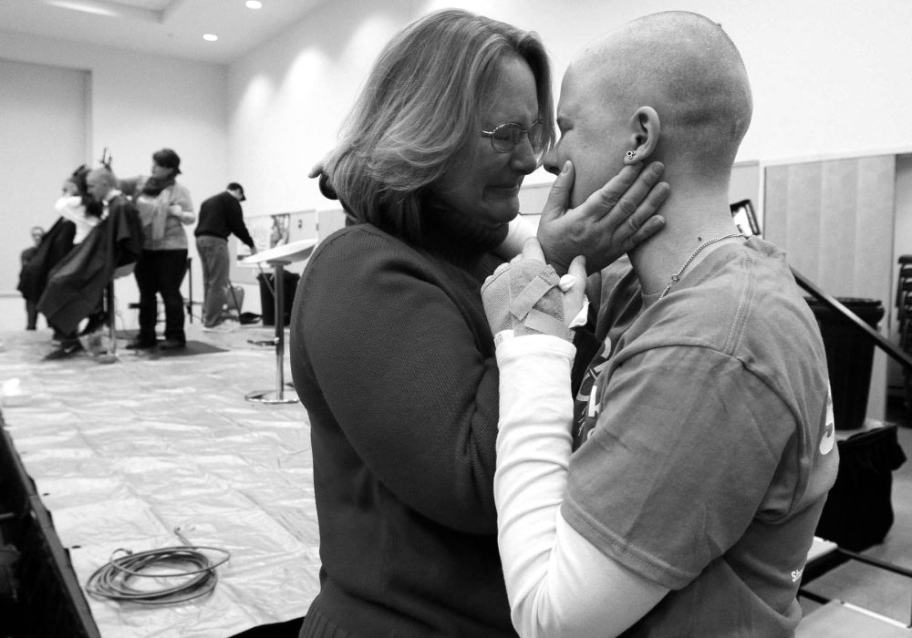 Award of Excellence, Feature - Amy E. Voigt / The (Toledo) BladeAnn Schlosser, hugs her daughter Megan  Schlosser, left, after Megan had her head shaved for a fund raiser for St. Baldrick's Foundation, which funds childhood cancer research grants. Ann Schlosser, from Canton, has stage 4 cancer and was given 3 months to live by her doctors. Four years later Mrs. Schlosser is still fighting. "I will always have it but I'm here!" Mrs. Schlosser said.