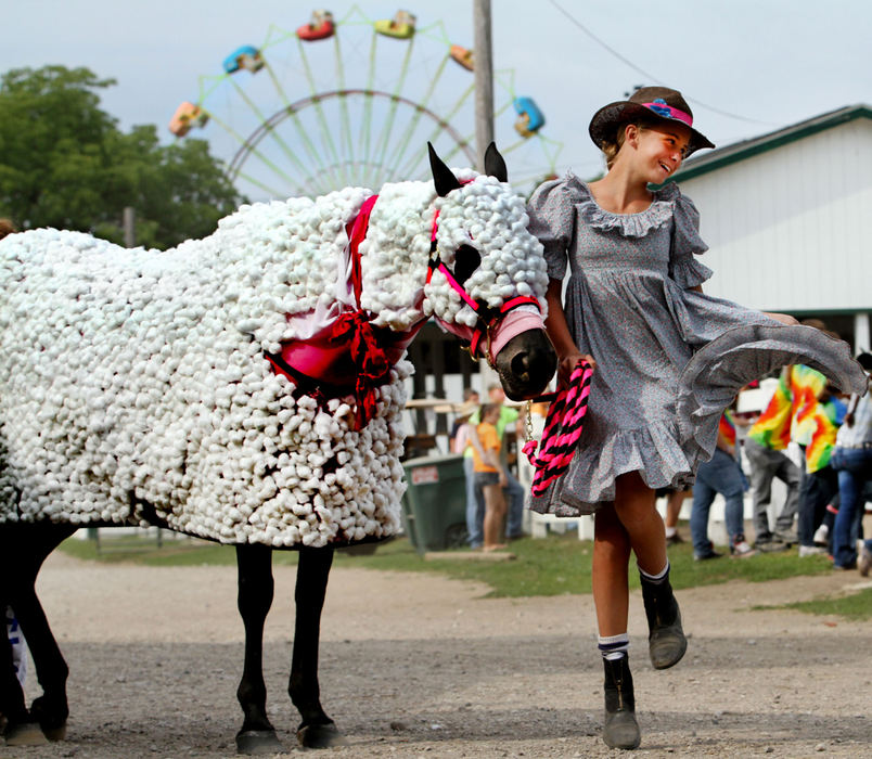 Award of Excellence, Feature - Lynn Ischay / The Plain DealerTwelve year old Haley Otto of Mentor gets into full 'Mary' mode while entering the ring with her "little lamb," quarterhorse mare Glory. Haley  got some help from her mother, Jennifer, in glueing more than 3000 cotton balls to Glory's blanket and face muzzle. "We cleaned out Giant Eagle," said Jennifer. Haley and 18 others competed in the walk-trot single costume class. Haley and Glory took first place, walking the ring to the tune of "Mary Had a Little Lamb."