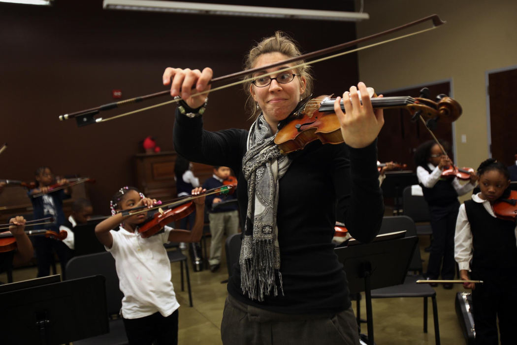 Second place, Feature Picture Story - Gus Chan / The Plain DealerInstructor Brittany Kubiak demonstrates the bunny bow during class.  The grip helps to build dexterity in the young musician's hands.