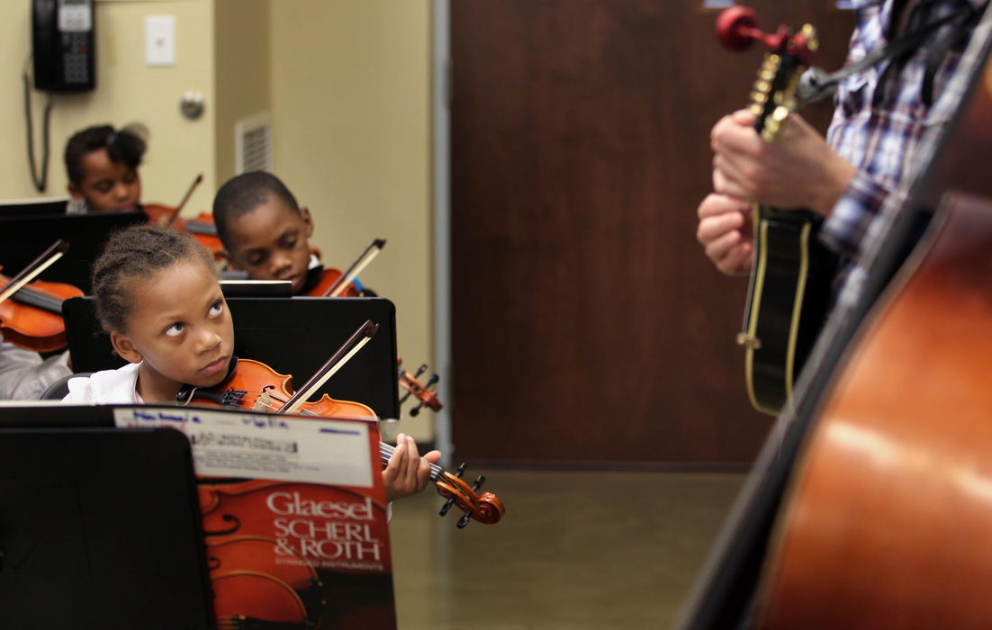 Second place, Feature Picture Story - Gus Chan / The Plain DealerMaiLonnie Walton watches as Brendan O'Malley of the folk group Honeybucket plays along with El Sistema @ Rainey.  Musical groups from all over the city come to Rainey weekly to perform in front of the orchestra.