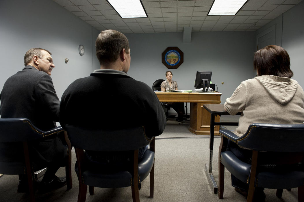 First place, Feature Picture Story - Abigail S. Fisher / Ohio UniversityAthens County Magistrate Melinda Bradford listens to a child support adjustment hearing in Athens, Ohio. Bradford works with Keith Wiens, far left, of the Athens County Child Support Enforcement Agency, hears cases every Wednesday and is often booked weeks in advance. Bradford estimates at least 4,000 child support hearings take place in the county each year.