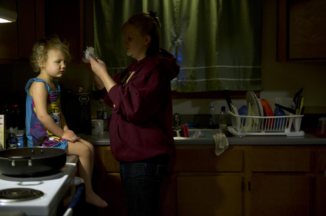 First place, Feature Picture Story - Abigail S. Fisher / Ohio UniversityTamara Newton gives her 3-year-old daughter, Mattie, cough medicine in the early morning. Tamara cooks a full, hearty breakfast for each of her daughters every morning before she leaves for college classes at Hocking College. Tamara, a single mom, gets some help raising her two daughters from her boyfriend, Aaron.