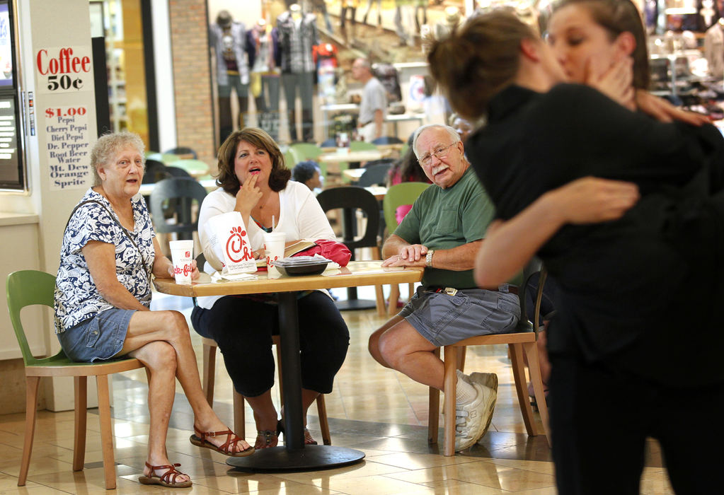 Third Place, General News - Katie Rausch / The (Toledo) BladeWanda Flory, of Swanton, center, watches with Terry, left, and her husband Richard, center right, as Thea Grabiec, right, kisses Sarah Shovan, Friday evening at the Westfield Franklin Park Mall in Toledo. Graviec and Shovan were participating in "National Same Sex Kiss Day at Chick-fil-A," a protest staged in response to Wednesday's "Chick-fil-A Appreciation Day." 