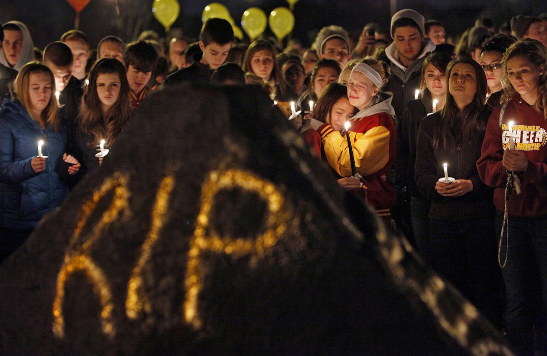 Award of Excellence, General News - Chris Russell / The Columbus Dispatch Westerville North High School students gather around a rock sprayed with reflective paint  during a candle light vigil outside the school. They were honoring  Leroy A. Gilkey, 38, a Spanish teacher at the school who was was murdered by his father during an argument about the care of his terminally ill mother. 