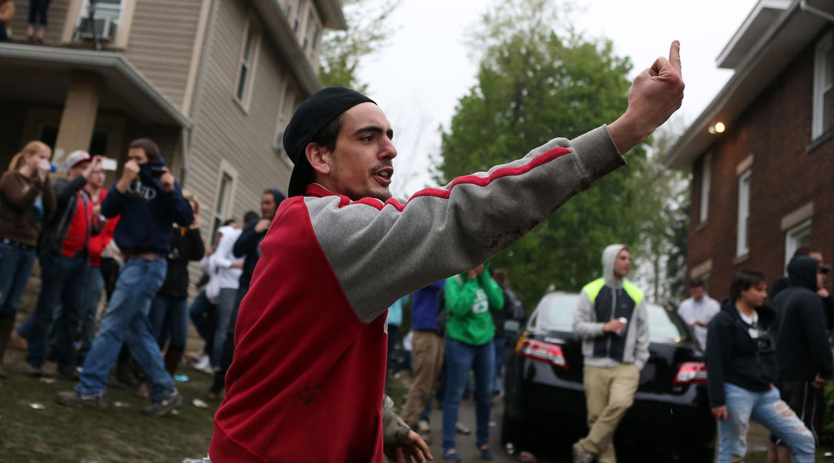Third place, News Picture Story - Coty Giannelli / Kent State UniversityA man flicks off police officers as they attempt to gain control of College Avenue.
