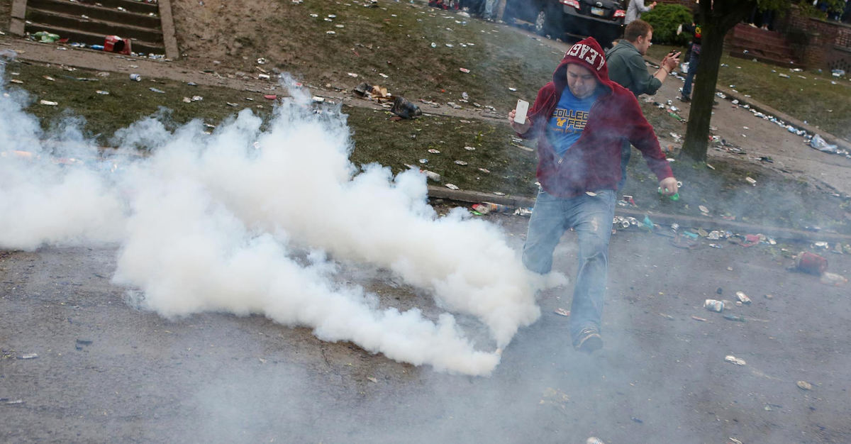 Third place, News Picture Story - Coty Giannelli / Kent State UniversityA partygoer kicks a can of tear gas off the street. A police taskforce returned to College Avenue in an armored personnel carrier. Armed with less-than-lethal munitions the police began to force partygoers off of College Avenue.