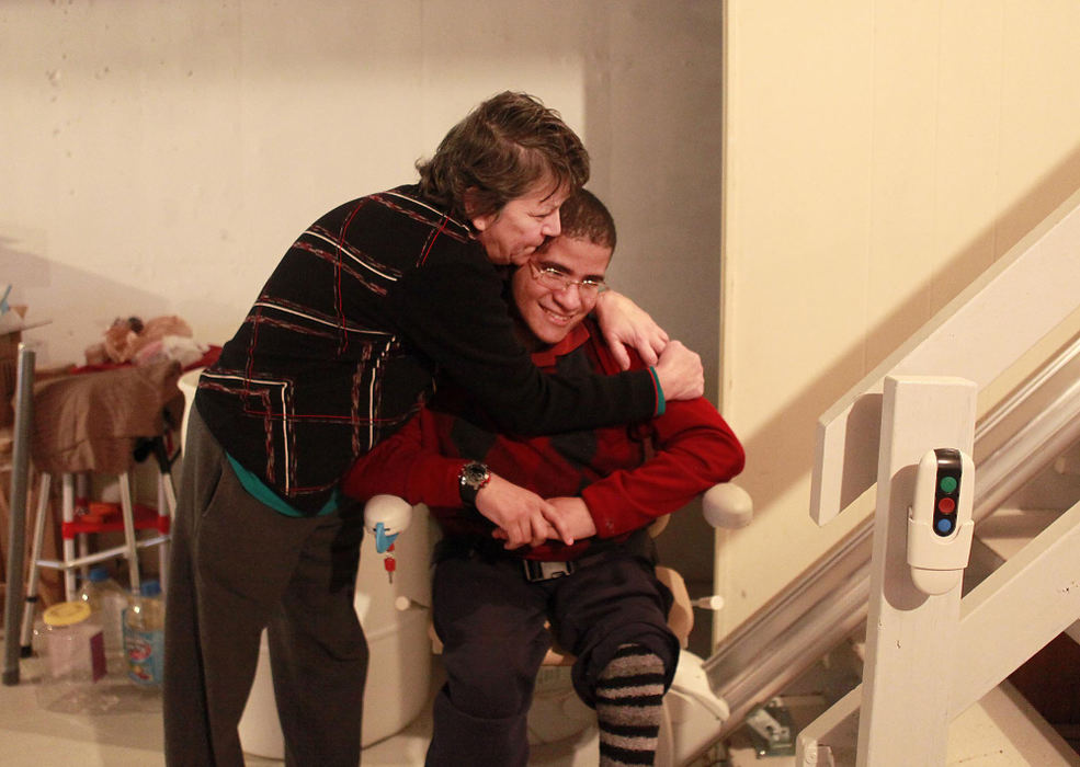 Award of Excellence, News Picture Story - Leigh Taylor / Cincinnati EnquirerJose Fred gets a hug from his mom Aida in the basement of their Anderson Township home.  Jose has spina bifida and uses a wheelchair, and is mostly highly indepedent.  He is very close to his family, which includes his parents and a brother and sister.  His father Jose, has been fighting bone cancer for several years.  Jose's family is very supportive of his adult independence and they think of the basement as Jose's apartment.  However, he cannot fully use the basement now because the bathroom is not accessible.  They are asking for funds to make the basement in the Fred's home accessible for Jose.  Jose is a hard-working and upbeat guy.  He says, "The most important thing is that you never lose your hope."  This is part of the Wish List series, which highlights needy people in the area and then asks for reader donations.  