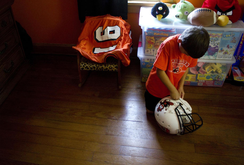 First place, James R. Gordon Ohio Understanding Award - Caitlin Bourque / Kent State UniversityVinny Keller plays with a former game helmet and jersey in his bedroom. His father, Matt, is an active participant in Massillon football, including the Boosters program and formally a participant in the Sideliners program where adults are paired with younger players to offer guidance and support as they go through high school. Oftentimes, they remain close after high school. One player, Shawn Wright, who is currently on active duty in Afghanistan, remains close to the family and especially Vinny