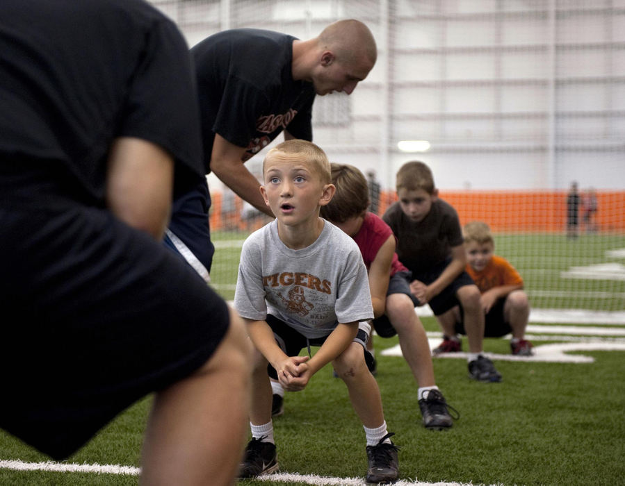 First place, James R. Gordon Ohio Understanding Award - David Foster / Kent State UniversityTyler Hackenbracht learns the proper blocking technique from members of the varsity football team during a youth camp held every summer in the Massillon Washington High School indoor facility. This three-day event is not only an opportunity for members of the team to share their knowledge and skills with children in the community, it’s also an opportunity to introduce the culture and tradition of Tiger football. 