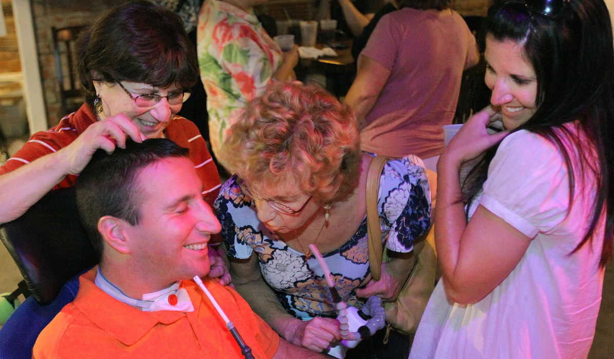 Award of Excellence, Photographer of the Year - Large Market - John Kuntz / The Plain DealerScott’s sister, Lindsey (right), his mother, Bobbi(left) and a family friend joke with him at a fund-raiser in August 2010. The few thousand dollars they raised helped pay for a $30,000 van and exercise therapy, which are not covered by Medicaid. 