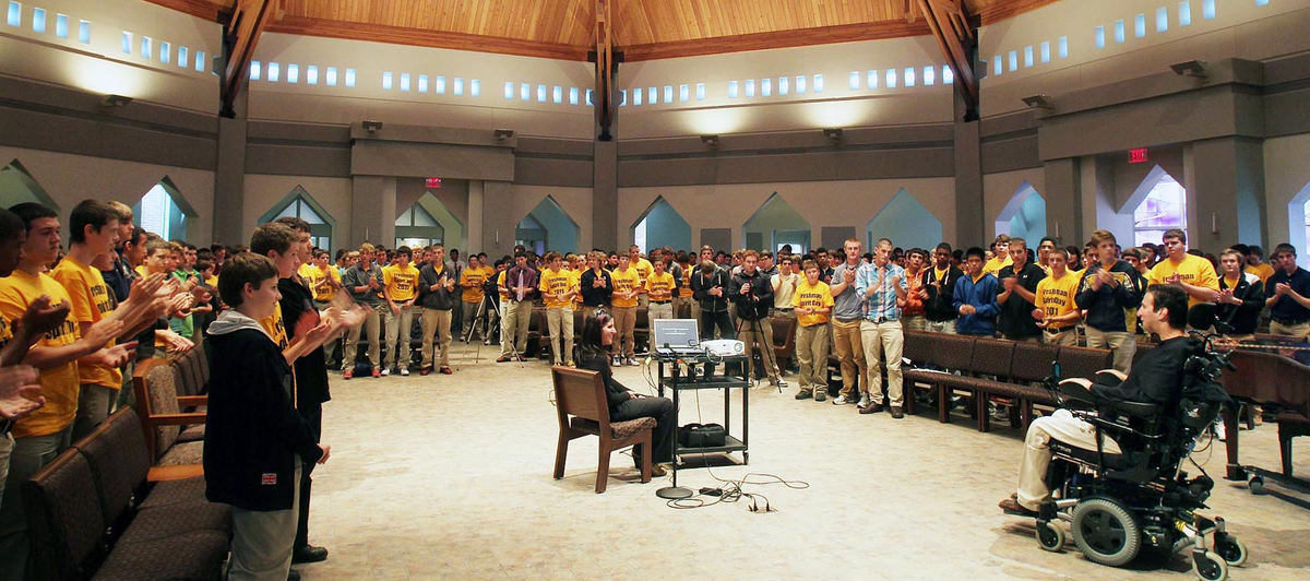 Award of Excellence, Photographer of the Year - Large Market - John Kuntz / The Plain DealerStudents and teachers at St. Ignatius High School in Cleveland, Scott’s alma mater, give him a standing ovation after one of the motivational speeches he delivers once or twice a week. He tells audiences about the hard times, but he also lets them know that he serves on the board of LEAP, an organization that helps people with disabilities live independently; and undergoes experimental treatment so doctors can better help others who are paralyzed.  Helping Scott with speech is his sister, Lindsey. 