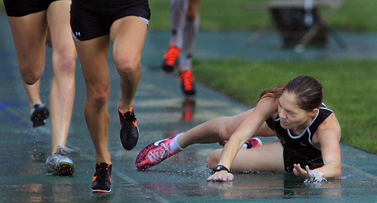 First place, Photographer of the Year - Large Market - Gus Chan / The Plain DealerRocky River's Madi Connelly, takes a tumble as she loses her footing on the rain soaked track in the girls 800 meter run in the regional track finals. Connelly was leading the entire race when she fell and was passed by Anna Boyert, of Medina, who won.
