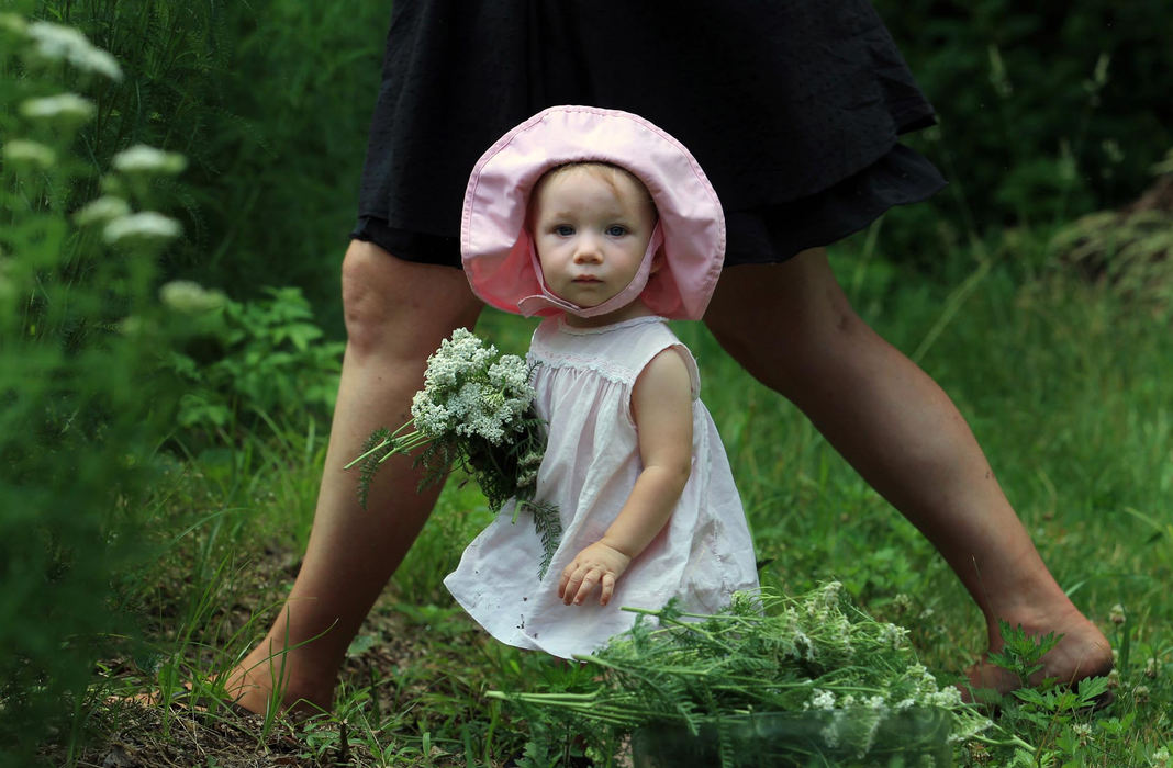 First place, Photographer of the Year - Large Market - Gus Chan / The Plain DealerGwyneth Neitenbach, 15 months, holds a bouquet of yarrow picked by her mother, Pamela, on the family farm.  The Neitenbach's run Neitenbach Farm, a Countryside Conservancy farm in the Cuyahoga Valley.  The farm specializes in vegetables and medicinal herbs.  The flowers will be used for a yarrow tincture, which has many medicinal properties.