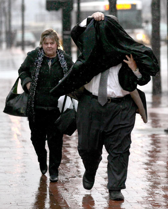 Third place, Photographer of the Year - Large Market - Marvin Fong / The Plain DealerFormer Cuyahoga County Commissioner Jimmy Dimora uses his coat to shield himself from cameras and rain as he enters the Federal Courthouse for his racketeering trial in Akron, OH.  