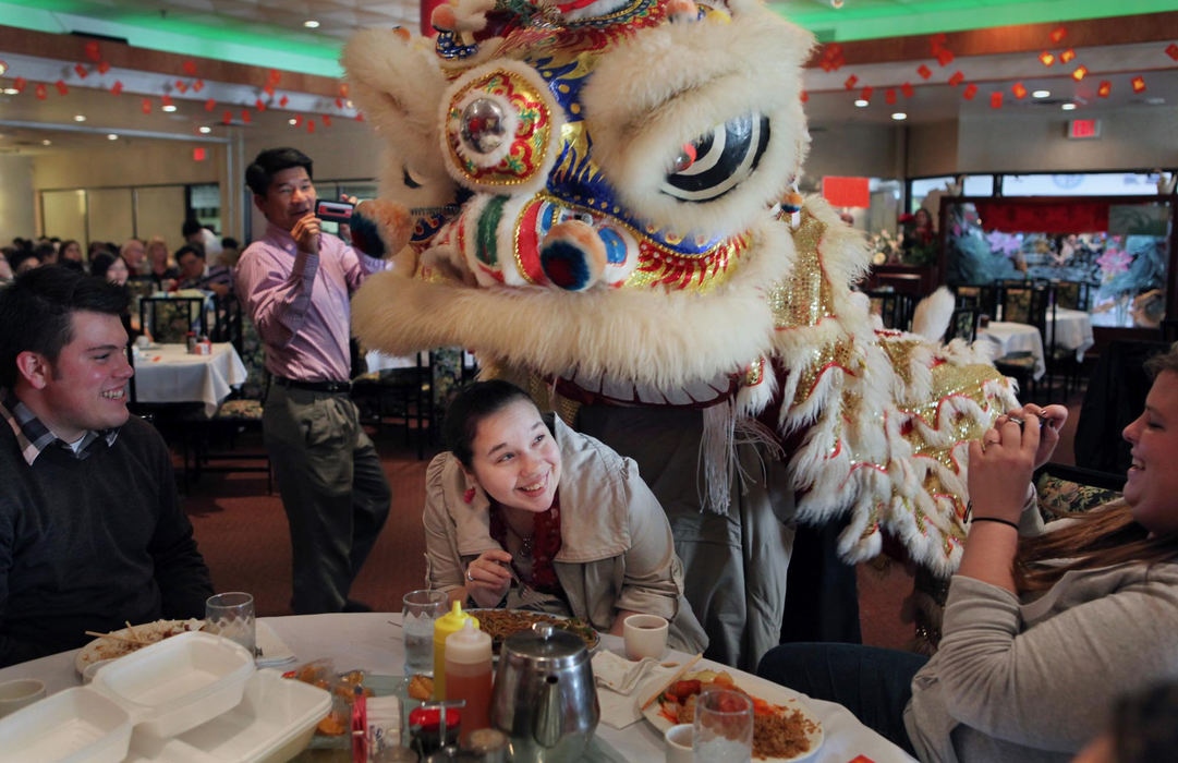 First place, Photographer of the Year - Large Market - Gus Chan / The Plain DealerBrook Rohrer, a senior at Malone College, meets the lion while eating lunch at Li Wah restaurant.  The Lion Dance, performed by the Kwan family helped usher in the Chinese Year of the Dragon. 