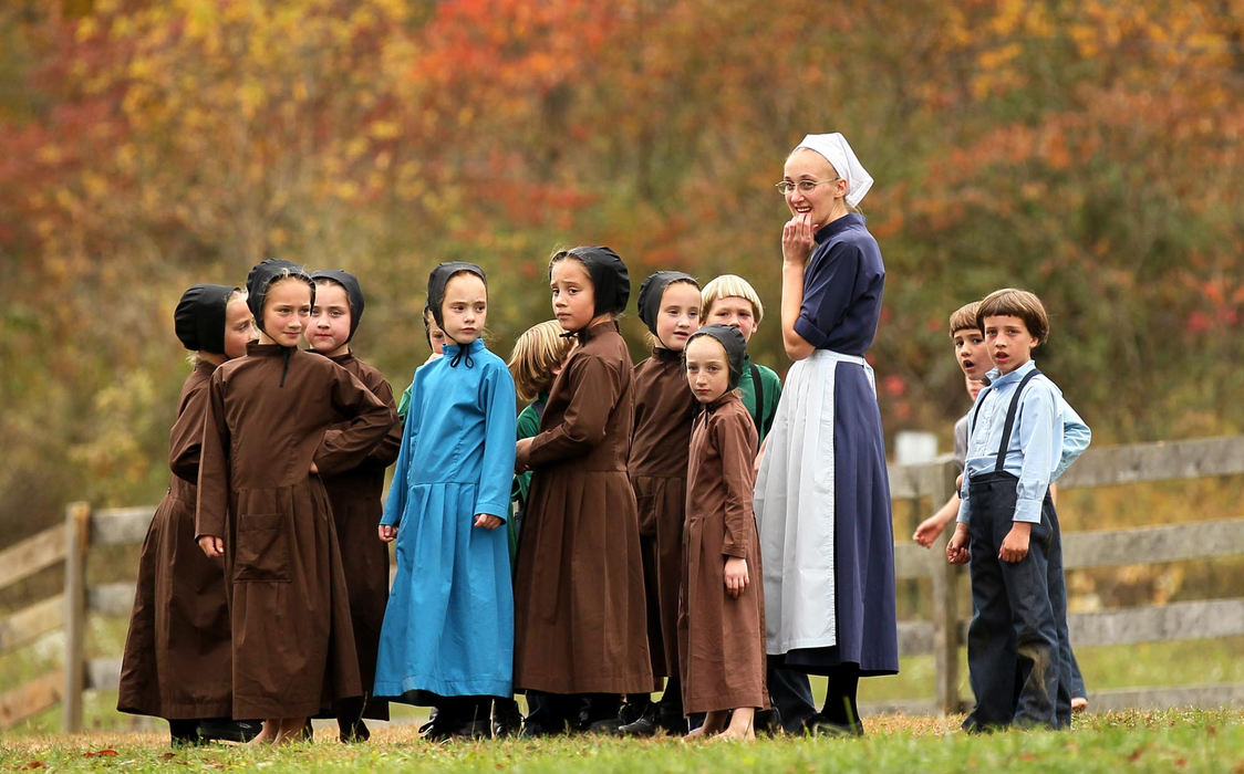 Third place, Photographer of the Year - Large Market - Marvin Fong / The Plain DealerTeacher Elizabeth Mullet stands with Amish children outside their school in Bergholz, OH.  Her father Sam Mullet was convicted and sentenced to 15 years for leading a series of beard and hair cutting attacks.  