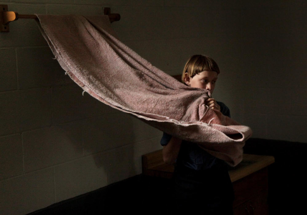 Third place, Photographer of the Year - Large Market - Marvin Fong / The Plain DealerAn Amish child wipes his face after washing his hands at his school house in Bergholz, OH.  Several family members convicted and  sentenced for hate crimes involving beard and hair cutting attacks, have kids at this school.    