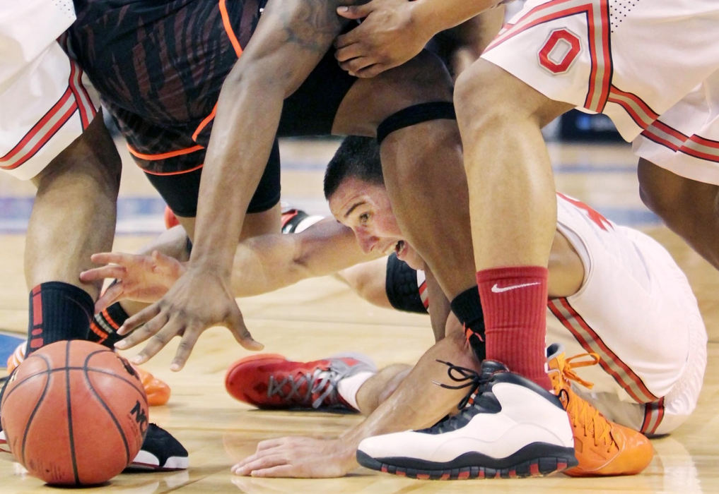 Award of Excellence, Photographer of the Year - Large Market - John Kuntz / The Plain DealerOhio State's Aaron Craft gets on the floor under the legs of Cincinnati's Yancy Gates to knock the ball from his hands in the second half during the regional semifinal game March 22, 2012 at the TD Garden in Boston, MA.  