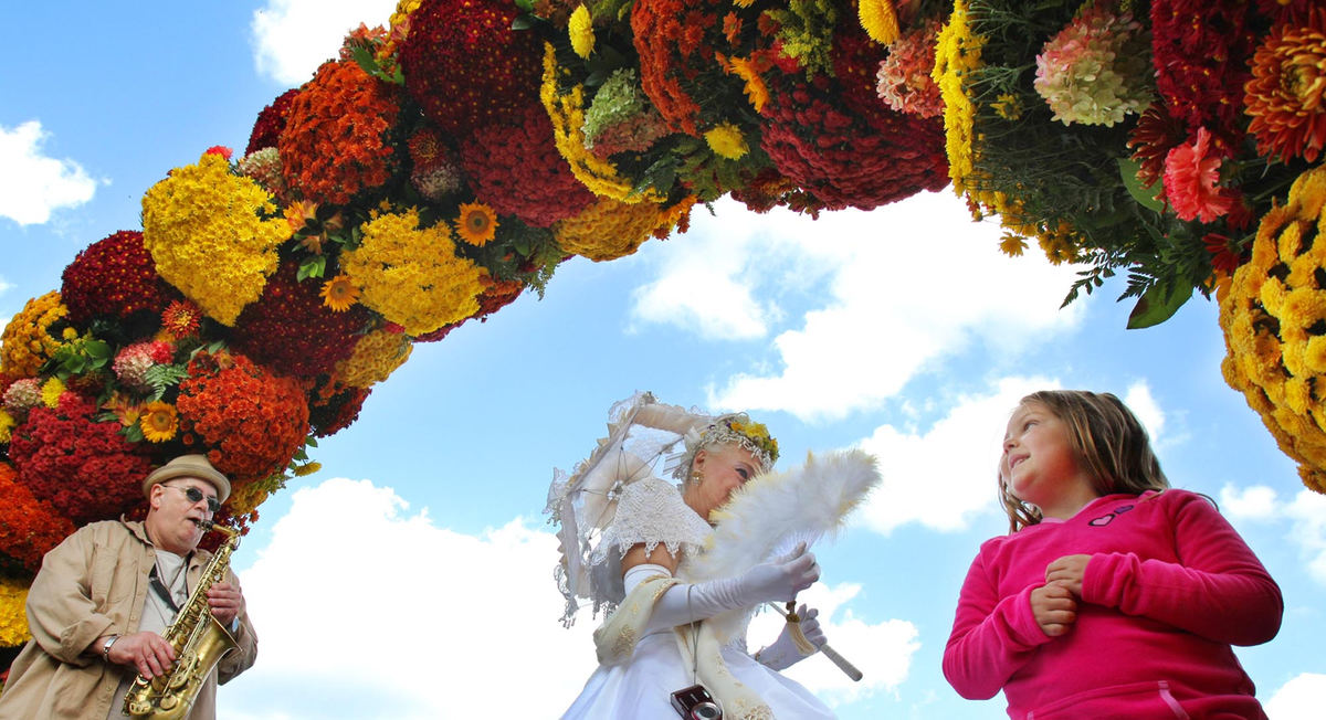 Award of Excellence, Photographer of the Year - Large Market - John Kuntz / The Plain DealerA young girl looks up at the Barberton Queen Mum, Karen Vinez of Barberton, as she walks under the arch made of mum plants while Denny Ott plays the alto saxophone September 29, 2012 during Barberton's Mum Festival at Lake Anna Park in the city's downtown.   