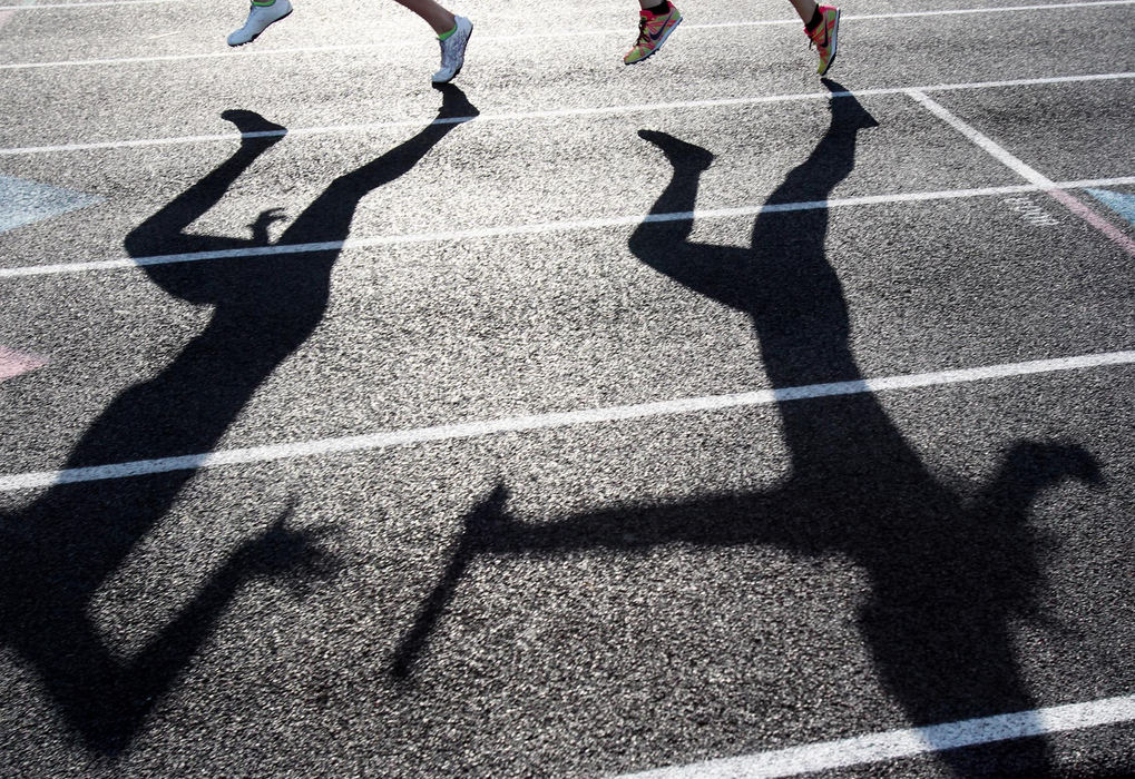 Award of Excellence, Photographer of the Year - Large Market - John Kuntz / The Plain DealerThe shadows of a baton hand off of the St. Joe's 4x200m relay team May 18, 2012 during the Division I District Track & Field Tournament hosted at Lakewood High School.  St. Joseph Academy won the event with a time of 1:44.90.  