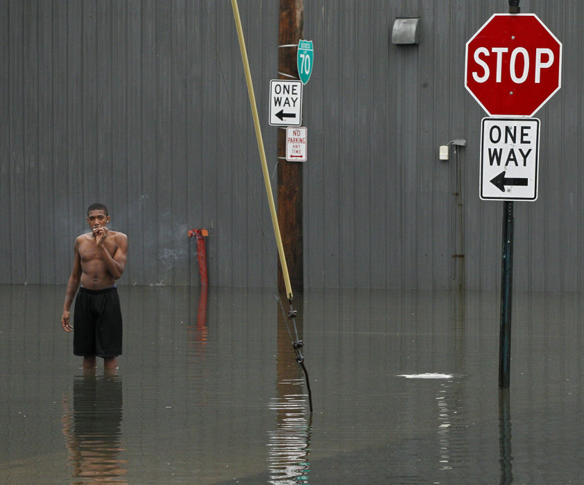 Second place, Photographer of the Year - Small Market - Barbara J. Perenic / Springfield News-SunJon Johnson, 18, smokes a cigarette while wading in a flooded portion of North Street following heavy rain associated with severe storms. Police closed the road for about an hour to let the storm water drain.