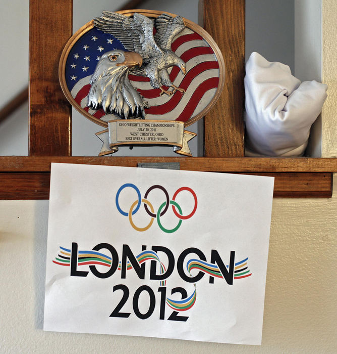 Award of Excellence, Sports Portfolio - Kyle Robertson / The Columbus DispatchA London Olympic sign hangs under a 1st place award in the living room of her apartment in Columbus, February 21, 2012. 