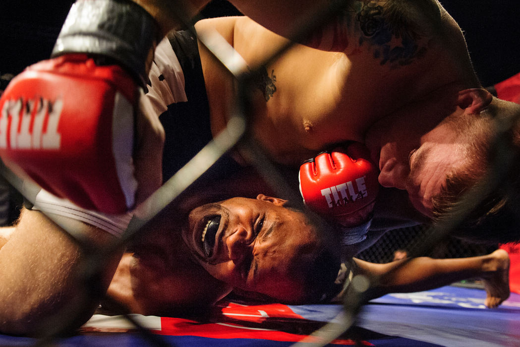 First place, Sports Portfolio - Joel Hawksley / Ohio UniversityDJ Weatherby grimaces as Robert White gains the upper hand in an amateur MMA match during the Arnold Sports Festival at the LC Pavilion in Columbus.