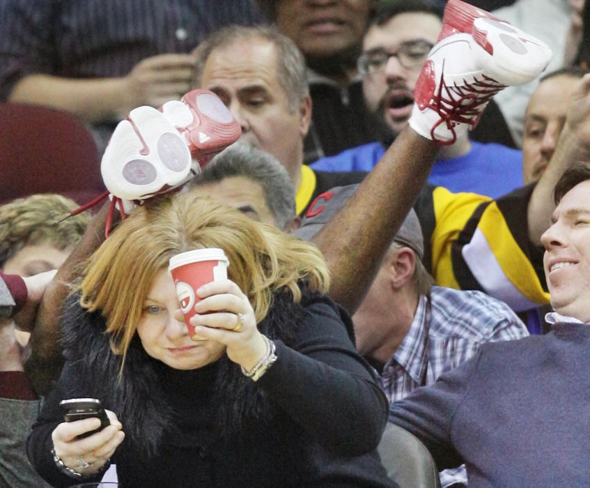 Award of Excellence, Sports Portfolio - John Kuntz / The Plain DealerA Cleveland Cavaliers fan is able so save her coffee as Cavaliers Antawn Jamison falls over her head in the third period against the Charlotte Bobcats January 3, 2012 at Quicken Loans Arena.  The Cavs went on to win the game, 115-101.  