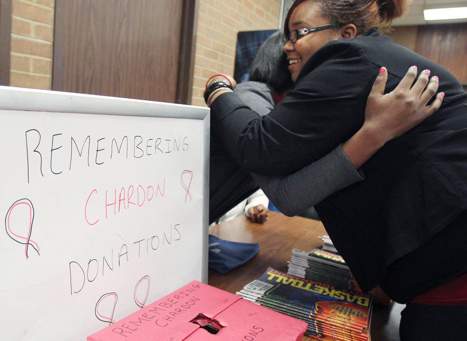 Award of Excellence, Sports Portfolio - John Kuntz / The Plain DealerEuclid High School student Diamon Hawkins hugs a fellow student at a table that the student non-violence group Stand Up set up for donations th Chardon High School March 1, 2012 before the start of Chardon's Division I sectional semifinal game against Madison High School hosted by Euclid High School.  The basketball game is the first school function since the fatal shootings in the Chardon High School's cafeteria three days prior.  For many Chardon students, this is the first time seeing fellow students.  The playoff game against rival Madison had a different tone from the opening of host Euclid High School's doors for the game.  Their were booths set up by the ticket counter to support and donate to Chardon along with counselors present in a side room.  The Madison basketball team wore black T-Shirts durig warm ups with Chardon printed on the front in solidarity with the Chardon players.  The players met at half court and locked arms for the national anthem, sobbing could be heard from the student body cheering section.  The game started and a sense of normalcy took over as Chardon Went on To win the game.                                             