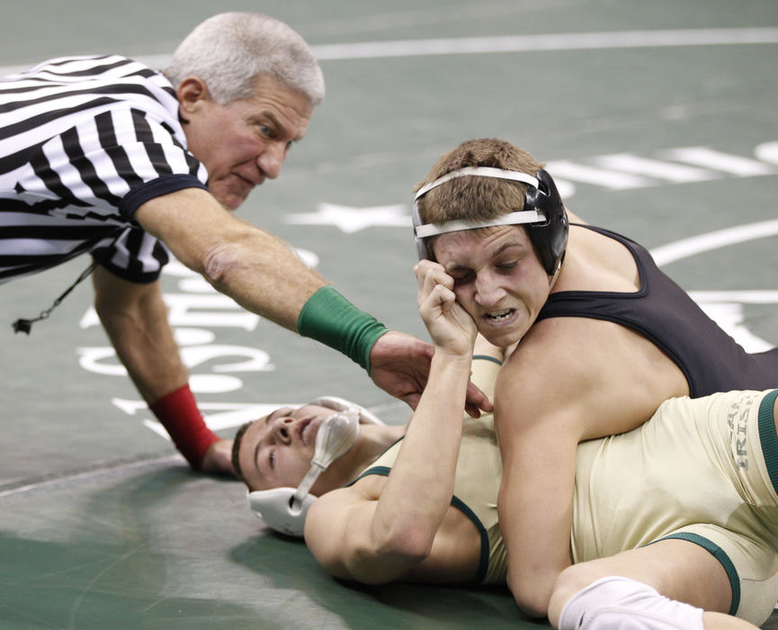 Award of Excellence, Sports Portfolio - Barbara J. Perenic / Springfield News-SunWrestling official Tony Campolo intervenes as Mike Rix of Akron St. Vincent-St. Mary twists the head of  Ryan Taylor of St. Paris Graham Local wrestle at 120 lbs. in Division II during the OSHAA State Wrestling Tournament.