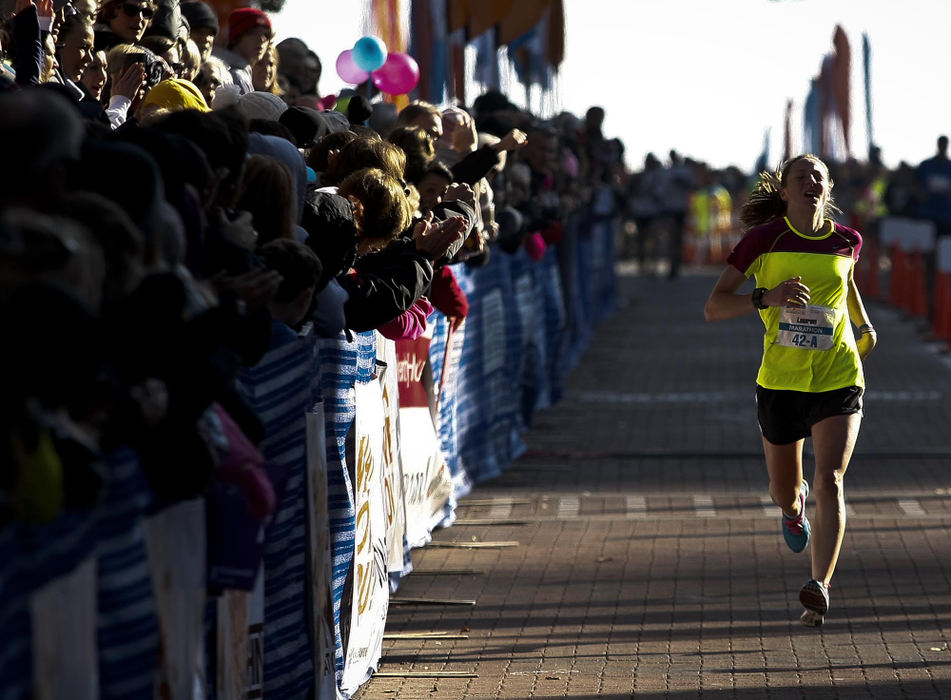 Award of Excellence, Sports Portfolio - Eamon Queeney / The Columbus DispatchLauren Woodring, of Bethel Park, PA, is the first woman to cross the full marathon finish line with a time of 2:45:31 during the Columbus Marathon Sunday morning, October 21, 2012. The annual Columbus Marathon packed 18,000 runners and walkers into the full and half marathons that snaked through the city on a cool and foggy fall morning. This year the Nationwide Children's Hospital was named the title beneficiary and at each mile there was a "patient champion;" 26 children, each with a life-altering story of disease. 