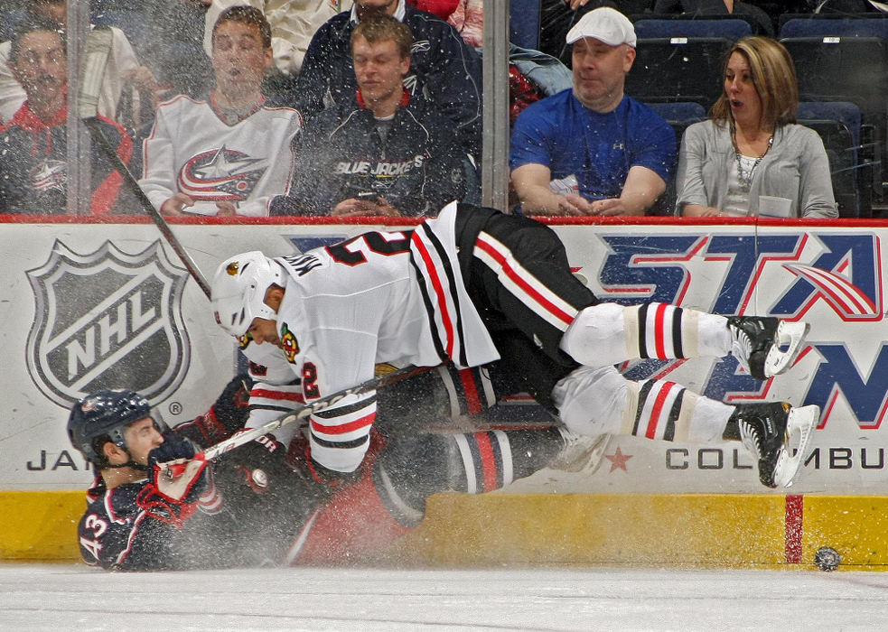 Award of Excellence, Sports Portfolio - Kyle Robertson / The Columbus DispatchColumbus Blue Jackets center Darryl Boyce (43) gets checked into the boards by Chicago Blackhawks right wing Jamal Mayers (22) in the 1st period of their NHL game at Nationwide Arena in Columbus, March 20, 2012. 
