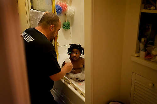 First place, Student Photographer of the Year - Meg Roussos / Ohio University Stauffer helps Azaria take a bath before bed time.