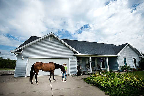 First place, Student Photographer of the Year - Meg Roussos / Ohio University Cody Venham, 12, stands with his horse, Streakin' Crow, in the middle of his drive way in Belpre. Venham started in rodeos when he was seven, specializing in heading, but also competes in barrels, goat timing, and steer roping. "Although he is very young, he races real close to all the older men he competes against," said his father, Dave.