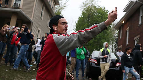 Third place, Student Photographer of the Year - Coty Giannelli / Kent State UniversityA man flicks off police officers as they attempt to gain control of College Avenue.