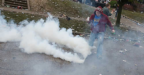 Third place, Student Photographer of the Year - Coty Giannelli / Kent State UniversityA partygoer kicks a can of tear gas off the street. A police task force returned to College Avenue in an armored personnel carrier. Armed with less-than-lethal munitions the police began to force partygoers off of College Avenue.