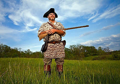 Award of Excellence, Student Photographer of the Year - Meg Vogel / Ohio UniversityGary George, a Living History Enthusiast from Albany, Ohio, holds his handcrafted 17th century rifle, while surveying his backyard in the colonial attire he wears for historical reenactments. George spent 500 hours crafting this rifle out of curled maple wood. 