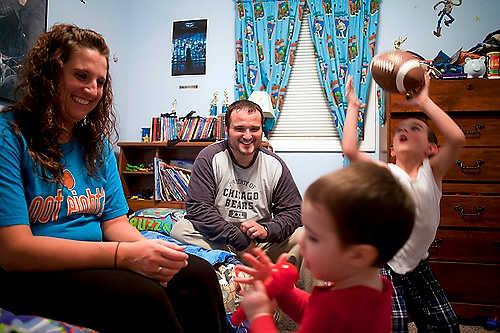 Award of Excellence, Student Photographer of the Year - Meg Vogel / Ohio UniversityJim and Stacie Forshey laugh as their youngest son, Preston, pretends to sing into a microphone before bedtime. Their oldest son, Devon, competes for his parent's attention and begs his dad to play football with him.