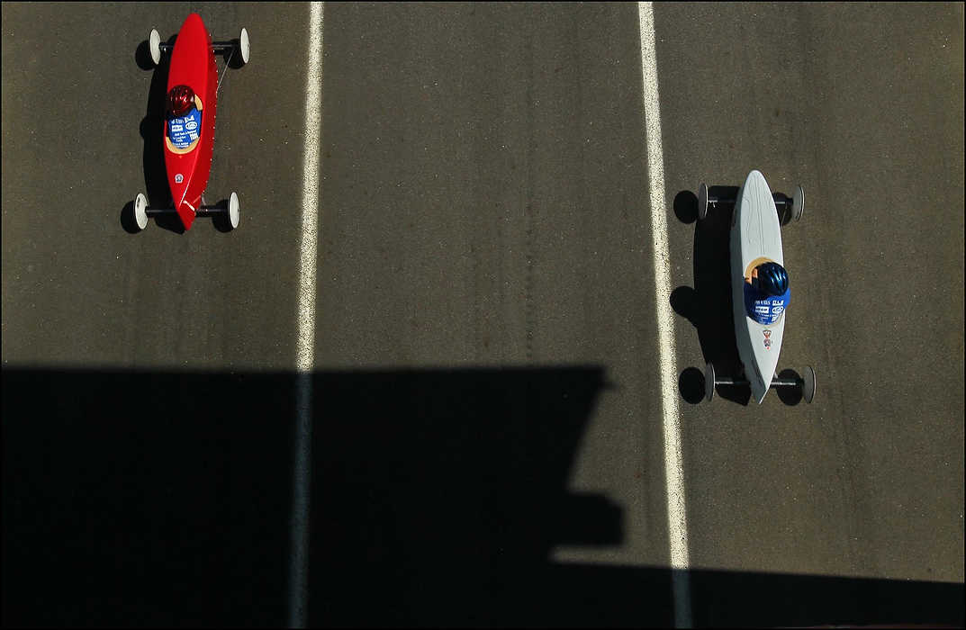 First place, Sports Picture Story - Ed Suba, Jr. / Akron Beacon JournalTwo racers emerge from the shadows after crossing the finish line while competing in their heat during the 75th annual FirstEnergy All-American Soap Box Derby at Derby Downs.