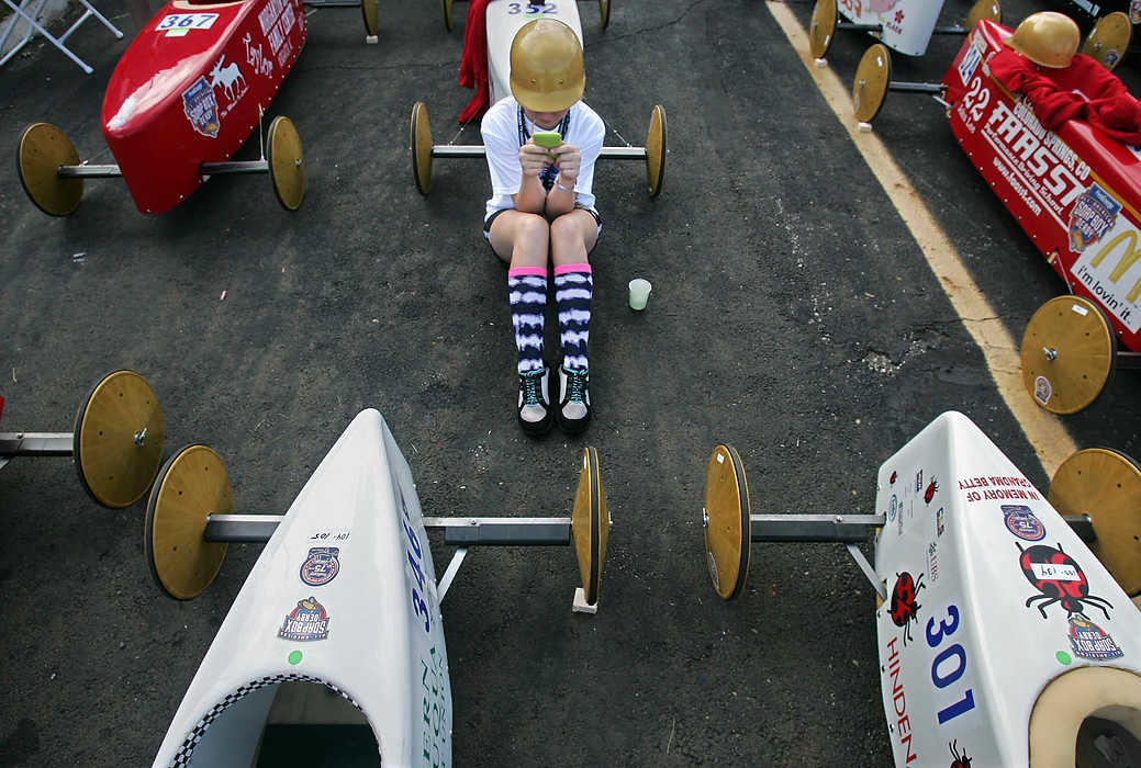 First place, Sports Picture Story - Ed Suba, Jr. / Akron Beacon Journal11-year-old Darian Allen of Lancaster, Ohio plays a game on her iPod while waiting for her heat in the Stock division at the 75th annual FirstEnergy All-American Soap Box Derby at Derby Downs.